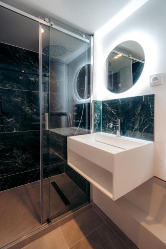 une salle de bain avec un lavabo et une douche en verre dans l'établissement Le Boudoir, à Fontainebleau