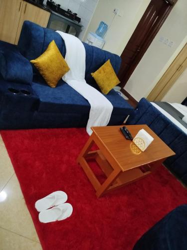 a living room with a blue couch and a table at Studio in Ruaka in Nairobi
