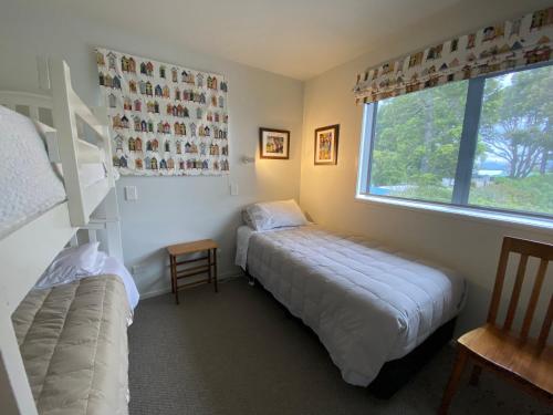 a bedroom with two beds and a window at Athenree Beach House in Athenree