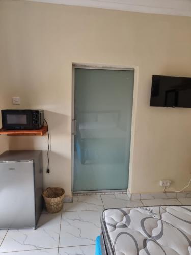 a sliding glass door in a room with a television at Gono Compound in Harare