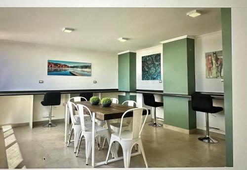 a dining room with a table and white chairs at Bello departamento in Los Ángeles