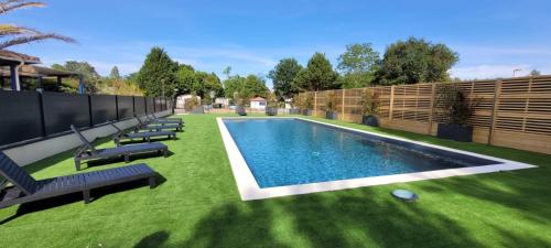 une arrière-cour avec piscine et pelouse dans l'établissement MOBILE-HOME au COEUR des LANDES, à Herm