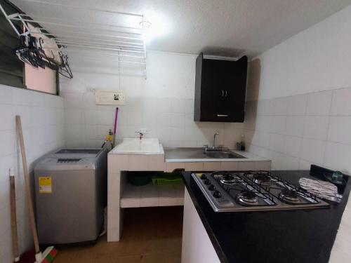 a small kitchen with a stove and a sink at Apartamentos CasaMJ Tunja Confort y Parqueadero in Tunja
