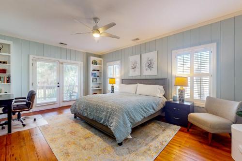 een slaapkamer met een bed, een bureau en een stoel bij Natural Wonder in Edisto Island