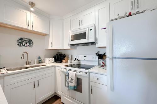 a white kitchen with white cabinets and a refrigerator at Grand Caribbean East & West W305 in Perdido Key