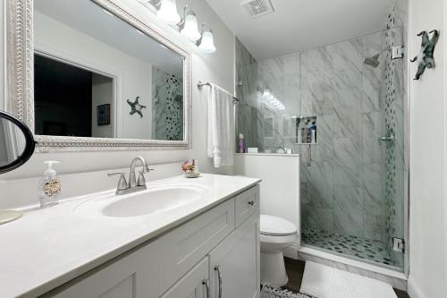 a white bathroom with a sink and a shower at Grand Caribbean East & West W305 in Perdido Key