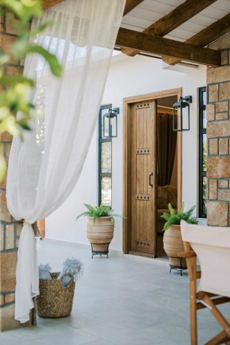 a porch with potted plants and a door at La Casetta della Nonna in Lardos