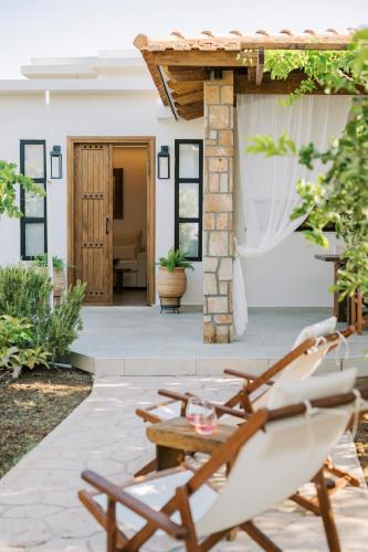 a patio with chairs and a table and a building at La Casetta della Nonna in Lardos