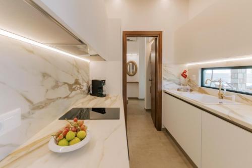 a kitchen with a bowl of fruit on a counter at La Casetta della Nonna in Lardos