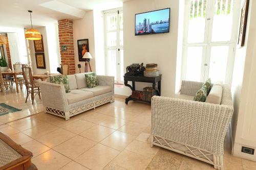 a living room with couches and a tv on the wall at Hotel Kartaxa in Cartagena de Indias