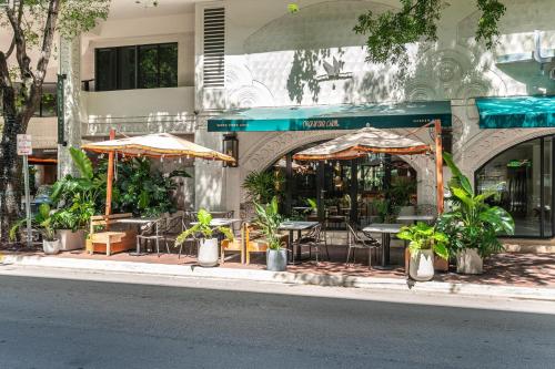 a restaurant with tables and chairs and umbrellas on a street at Renovated Coconut Grove Studio includes Parking in Miami