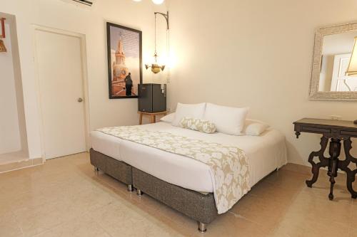 a bedroom with a large bed and a table at Hotel Kartaxa in Cartagena de Indias