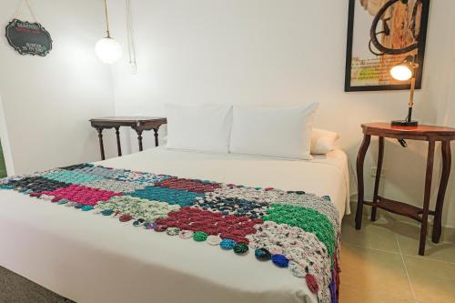 a bed with a crocheted blanket on it at Hotel Kartaxa in Cartagena de Indias