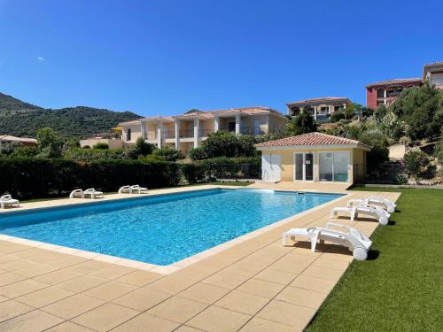 une piscine avec des chaises longues à côté d'une maison dans l'établissement Bel appartement, terrasse vue mer, Sant Ambroggio, à Lumio