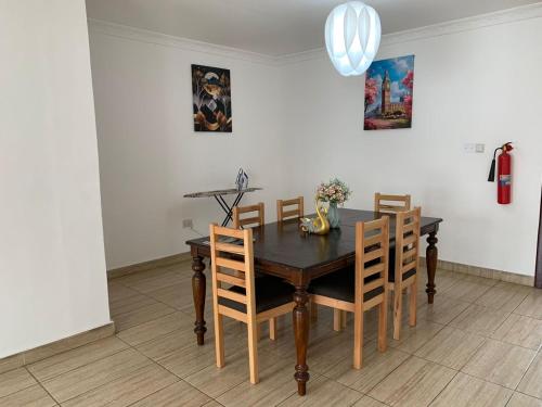 a dining room with a wooden table and chairs at American Mall apartment, Osu in Accra