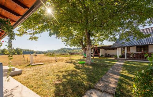 a tree in the yard of a house at Nice Home In Gospic With Wifi in Gospić