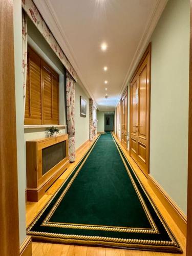 a hallway with a green carpet in a building at Stud House in Private Country Estate near Bruton in Gillingham