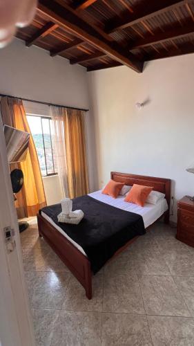 a bedroom with a large bed with orange pillows at Apto. en zona céntrica con vista panorámica al pueblo in San Gil