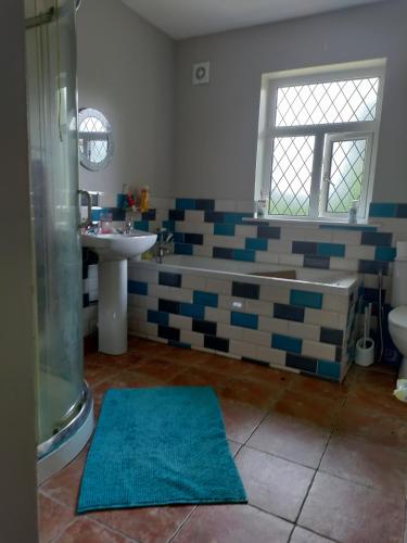 Un baño con bañera, lavabo y ducha. en Long Acre, Holiday rental in Central Manorhamilton, Leitrim, en Leitrim