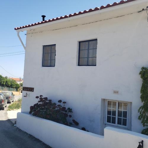 a white house with windows and a plant at Casa Hortensia in Cardigos