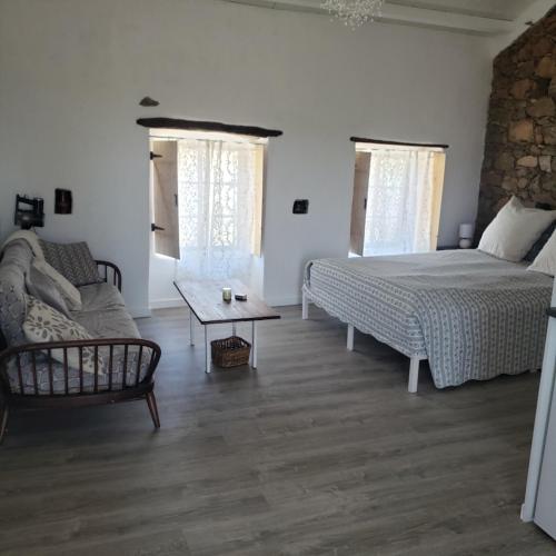 a bedroom with a bed and a couch and a table at Casa Hortensia in Cardigos