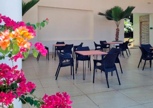 a room with tables and chairs and flowers at HOTEL SANTAFE NATURA - SANTAFE DE ANTIQUIA in Santa Fe de Antioquia