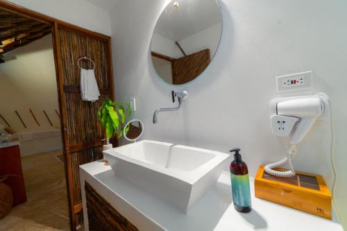 a bathroom with a white sink and a mirror at Vista Mare Beach House in Tierra Bomba