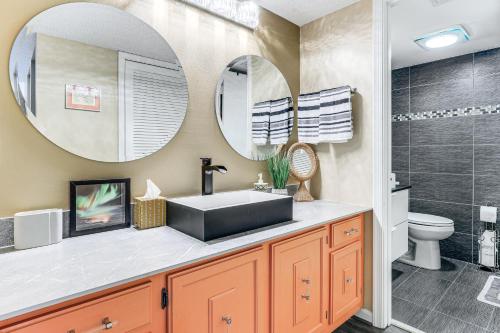 a bathroom with a sink and two mirrors at Condo with Patio and Resort Amenities in Fort Pierce! in Fort Pierce