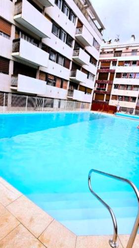 une grande piscine devant un immeuble dans l'établissement Appartement cosy avec piscine, à Perpignan