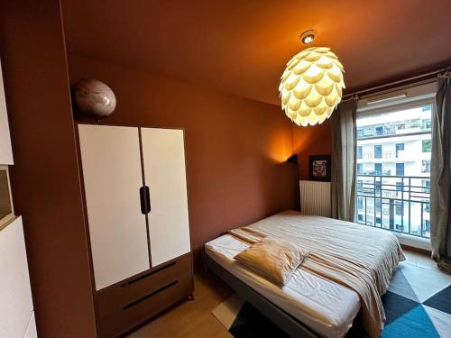 une chambre avec un lit et une grande fenêtre dans l'établissement Appartement à 10 min centre Paris métro 13 et 14, à Saint-Ouen