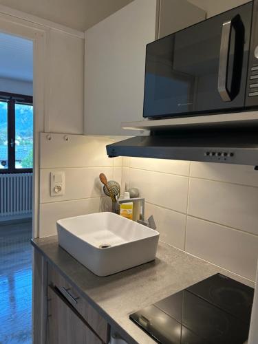 La cuisine est équipée d'un évier blanc et d'un four micro-ondes. dans l'établissement Chamonix Residence les Periades, à Chamonix-Mont-Blanc