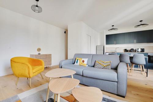 un salon avec un canapé bleu et un fauteuil jaune dans l'établissement Flexliving - room - Fessart, à Paris