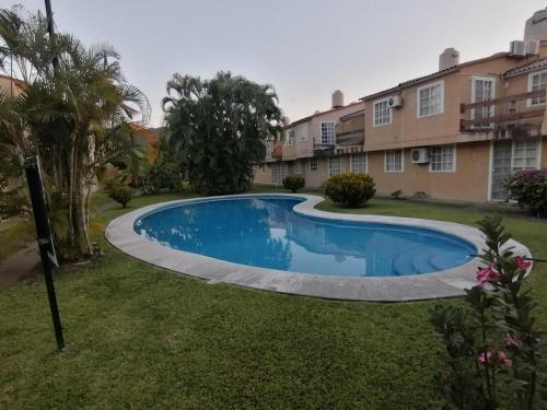 a swimming pool in the yard of a building at Casa Cayo in Ixtapa