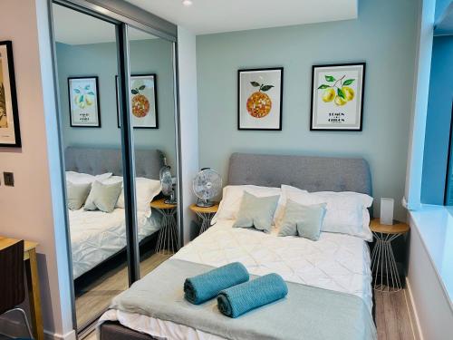 ein Schlafzimmer mit einem Bett und einem Spiegel in der Unterkunft Stylish studio apartment, One Thames Valley in Bracknell