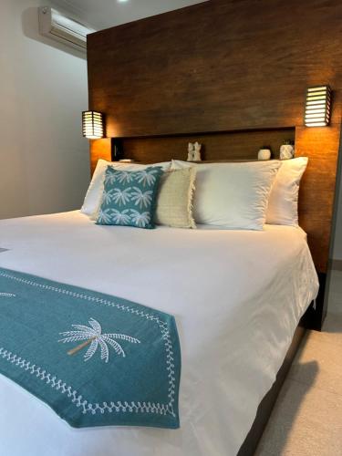 a bedroom with a large white bed with a wooden headboard at Kaien Villas Gili Air in Gili Air