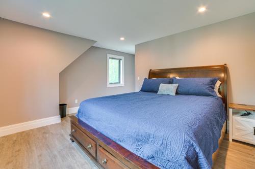 a bedroom with a bed with a blue comforter at Cottage on Crooked River with Dock and Slip! in Alanson
