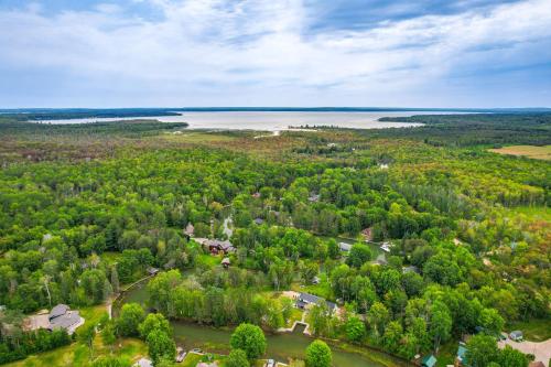 an aerial view of a subdivision of trees and a lake at Cottage on Crooked River with Dock and Slip! in Alanson