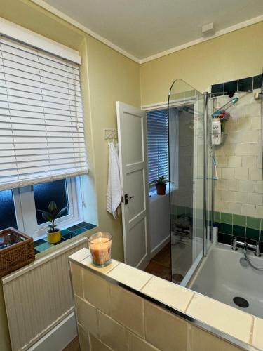 a bathroom with a shower and a bath tub at Happy Homestay London in London
