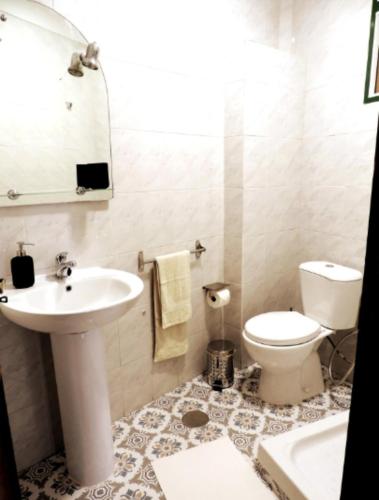 a white bathroom with a sink and a toilet at Casa La Ladera in Hermigua