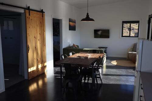 a kitchen and dining room with a table and chairs at Hygge Eco Cabins Beautiful New Cabins with Amazing Views in Jindabyne
