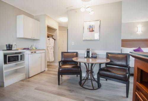 a kitchen with a table and two chairs in a room at Coast Parksville Hotel in Parksville