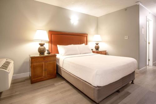a bedroom with a bed and two lamps on night stands at Coast Parksville Hotel in Parksville