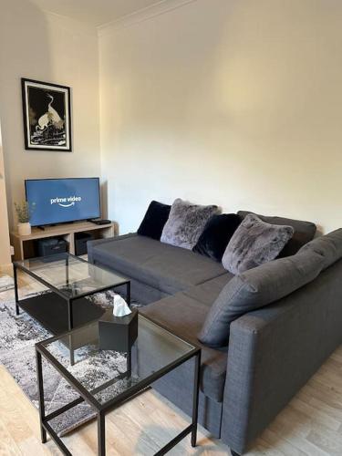 a living room with a couch and a tv at 5min to Huddersfield Royal Infirmary Hospital in Lindley