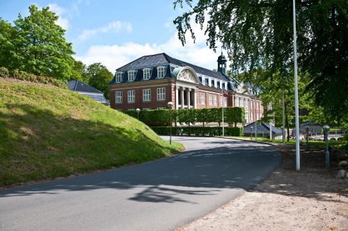 a large red brick building on a street at Hotel Koldingfjord in Kolding