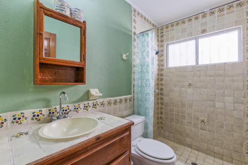 a bathroom with a sink and a toilet and a mirror at La Gaviota in Puerto Peñasco