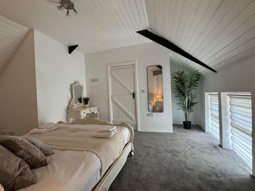 a white bedroom with a large bed and a window at 7 Person home With HOT TUB in Blackwater