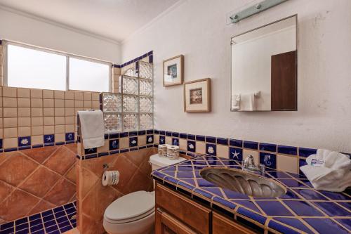 a bathroom with a sink and a toilet and a mirror at Mariposa in Puerto Peñasco