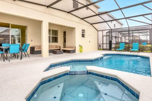 a swimming pool with blue chairs and a table at Upstay - Themed Family Home w Pool & Games Room in Kissimmee