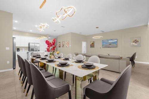 a dining room with a long table and chairs at Upstay - Themed Family Home w Pool & Games Room in Kissimmee