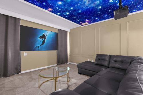 a living room with a couch and a screen with stars at Upstay - Themed Family Home w Pool & Games Room in Kissimmee